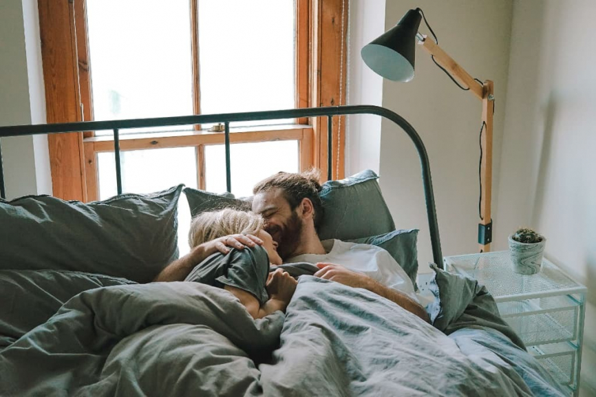 ベッドの中で抱き合うカップル