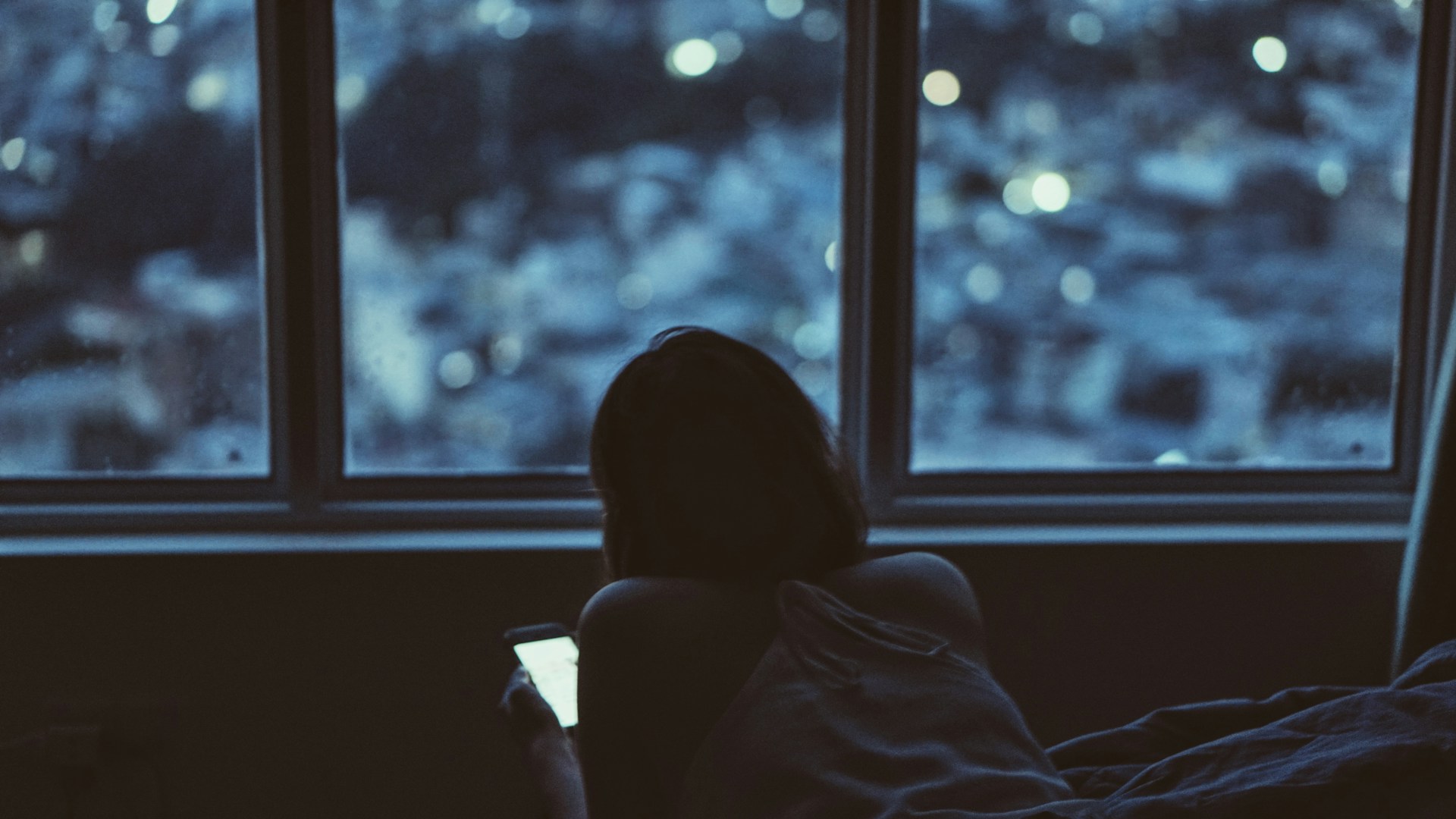 寝る前にスマホを見ている女性